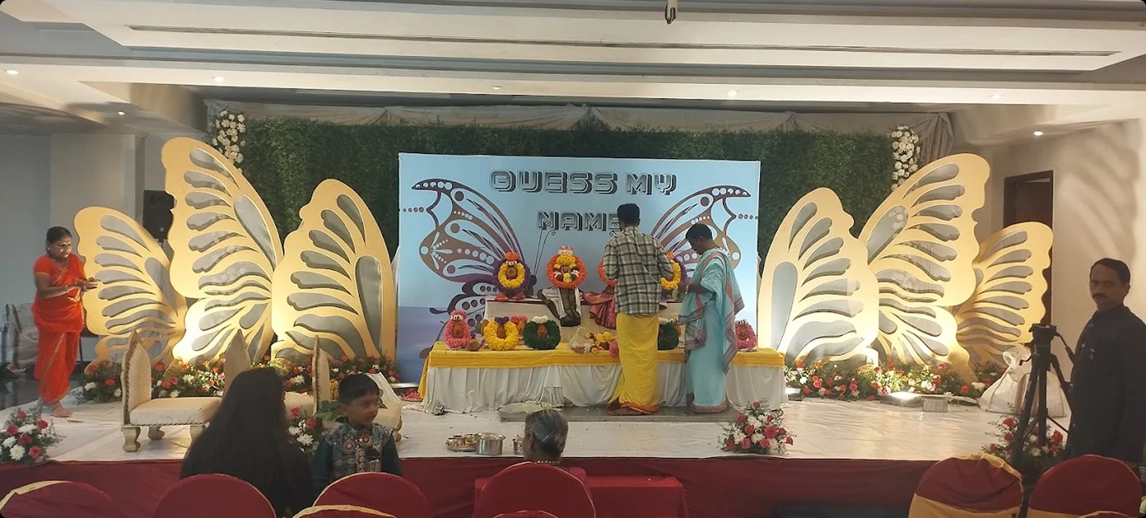 The main hall mid-ceremony, gold butterfly stage backdrop and guest seating, at Sri Sai Convention Hall, Jayanagar 9th Block, Bengaluru