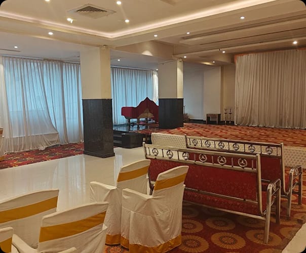 The air-conditioned main hall draped in white with the stage set for a function, Sri Sai Convention Hall, Jayanagar