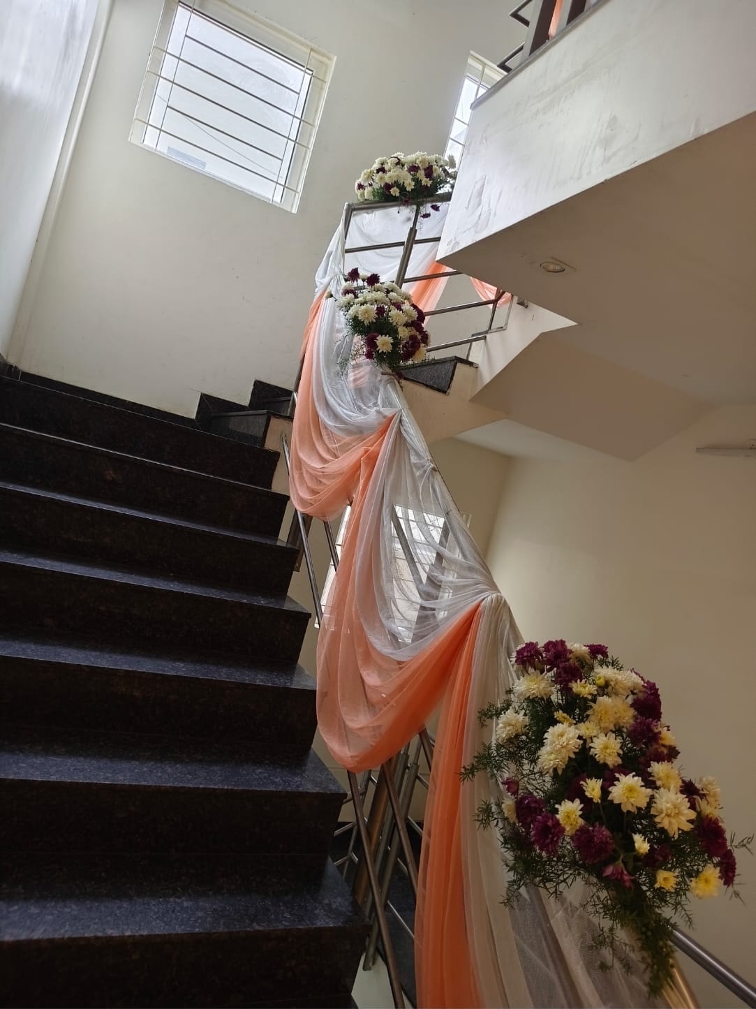 The staircase to the first floor dressed with floral drapes at Sri Sai Convention Hall, Jayanagar